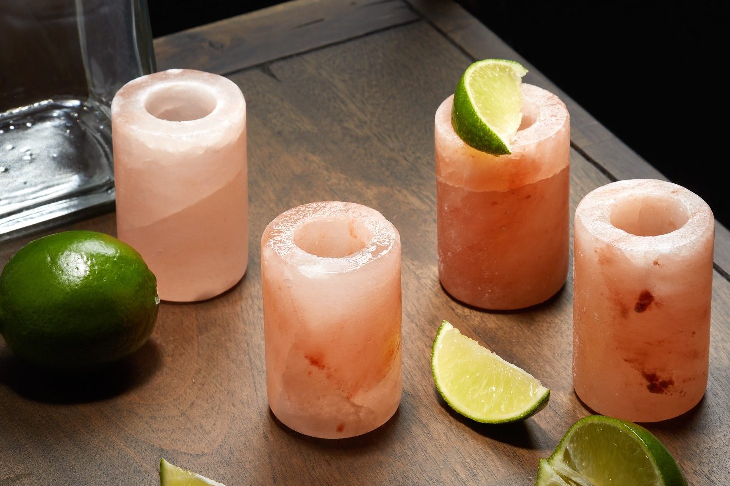 Himalayan salt shot glasses with lime on a wooden board